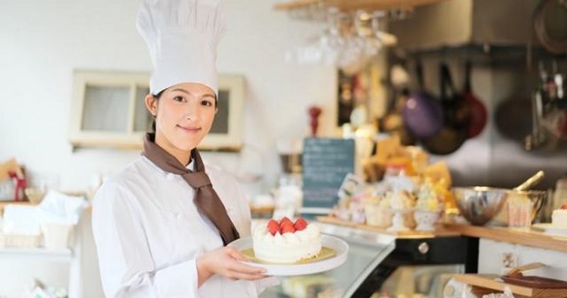 ケーキを持つ女性パティシエ